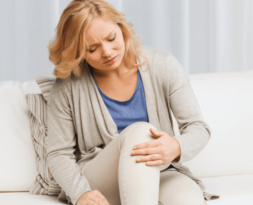 woman holding knee in pain from inflammation
